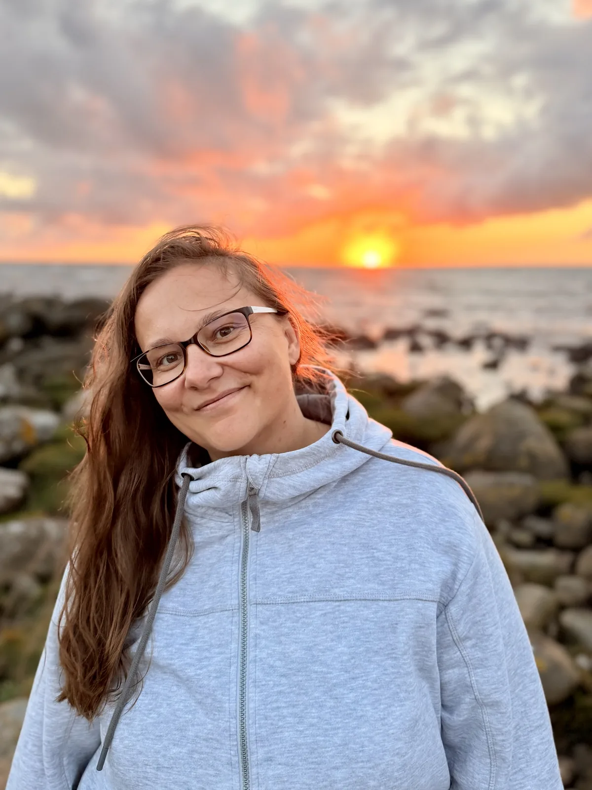 Maria Lengemann vor einem Sonnenuntergang am Meer, Porträt